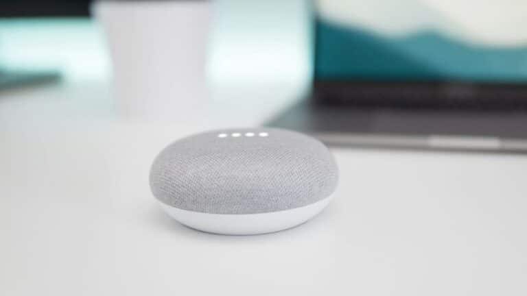 caixa de som bluetooth pequena da cor cinza em cima de uma mesa