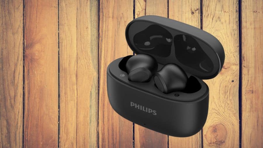 Fone Bluetooth Philips preto dentro do estojo sobre superfície de madeira rústica, usada como imagem destacada do artigo